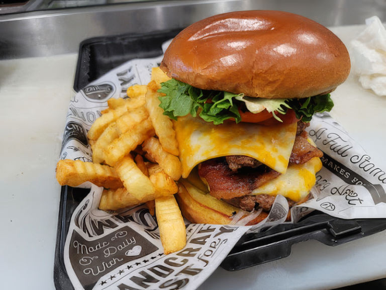 Cheeseburger with bacon, melted cheese, and crinkle-cut fries from a local restaurant near Caledonia, Mississippi